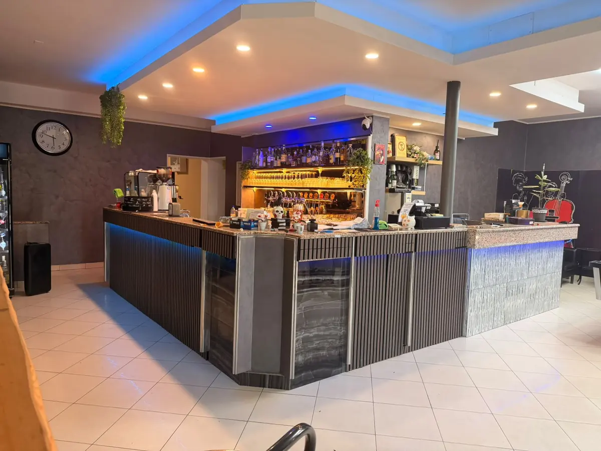 Il bancone della Pizzeria Canguro Nero con le luci blu e le bottiglie illuminate