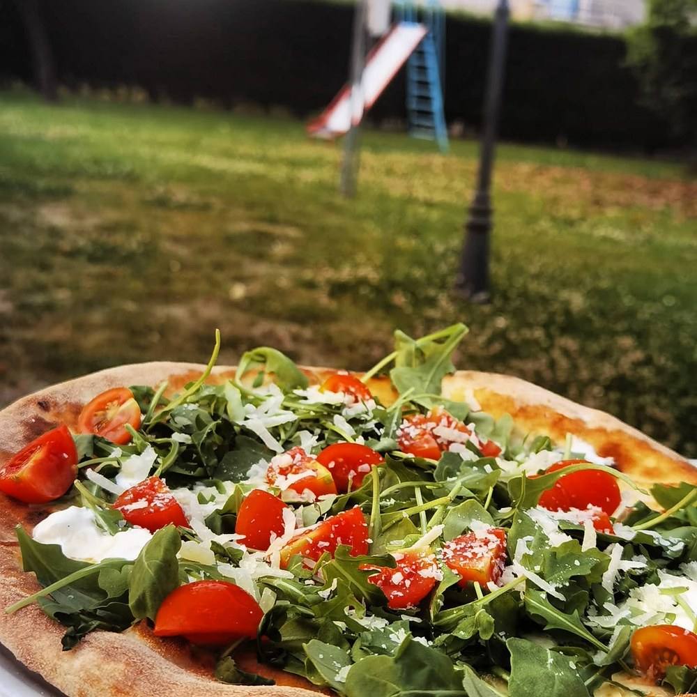 Pizza con bresaola, rucola, pomodorini e scaglie di grana
